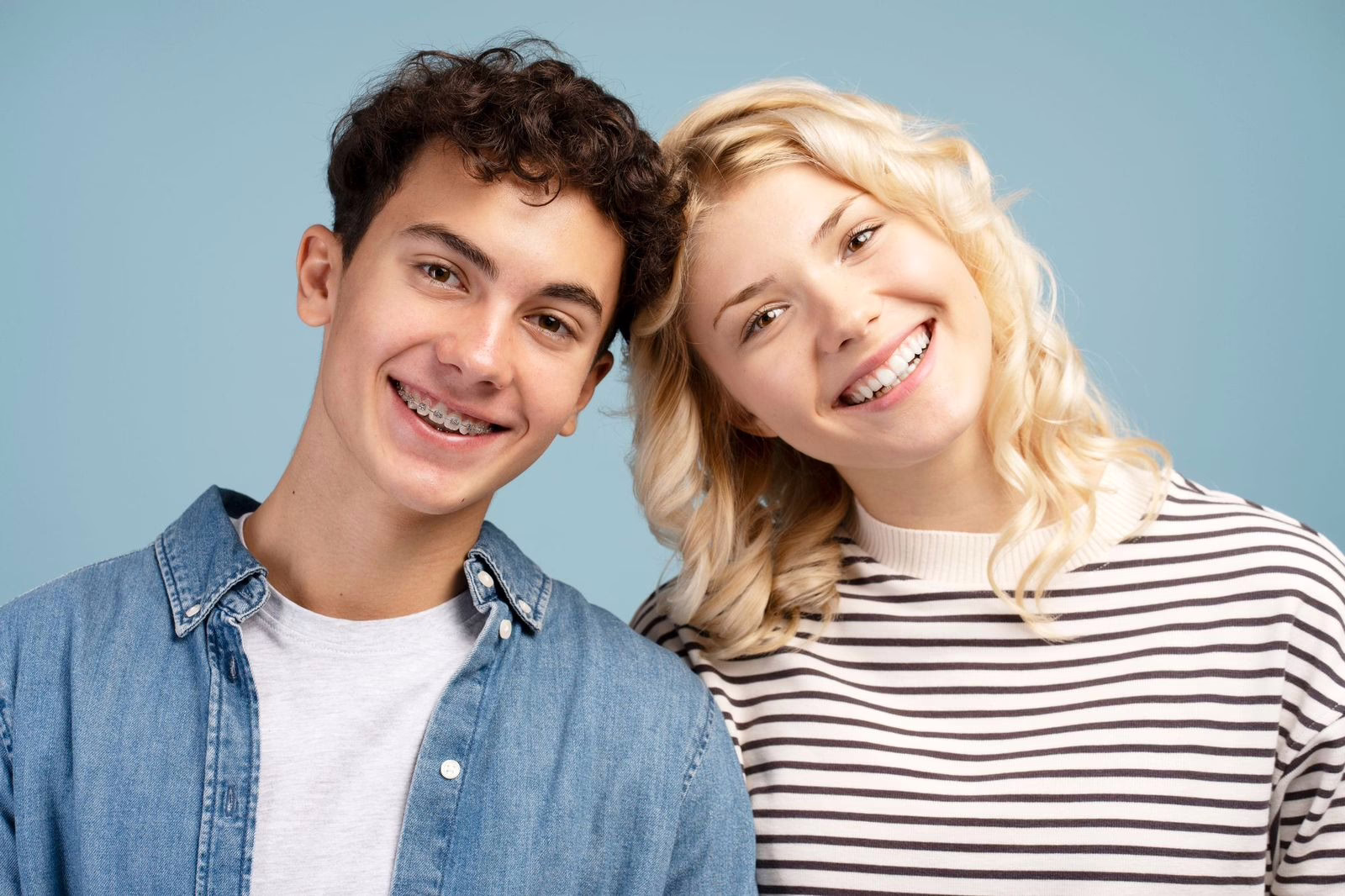 Teens smiling with braces and Invisalign